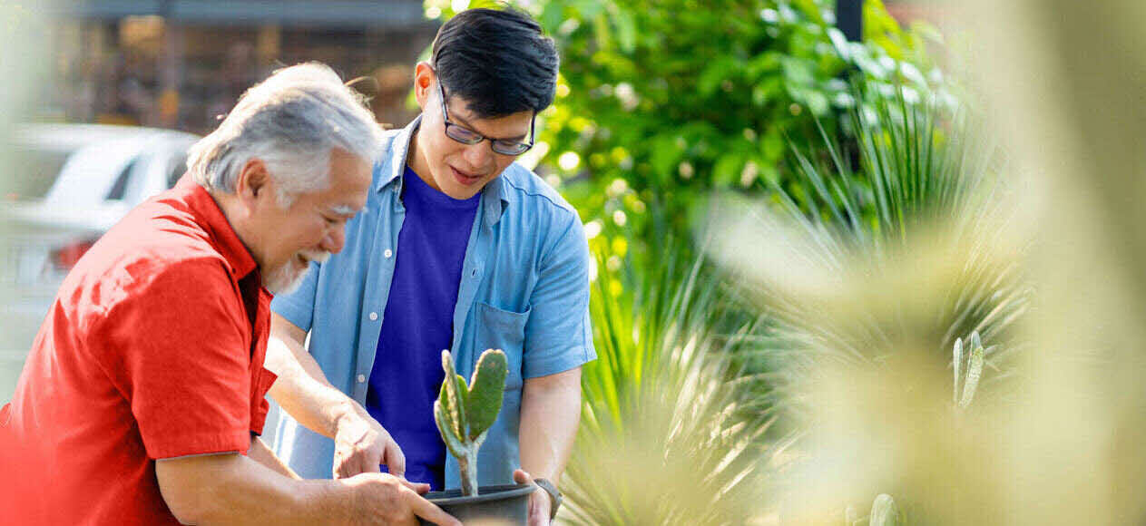 Father and son picking a plant together