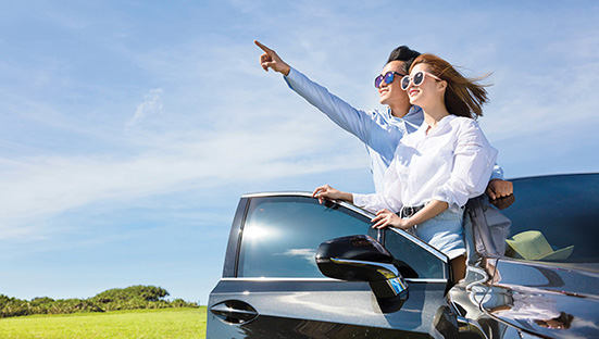 young couple standing near the car and enjoy summer vacation